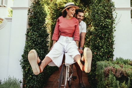 Cheerful couple riding a bike together outdoors