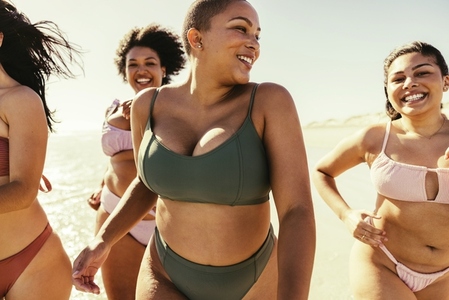 Women running in bikinis at the beach