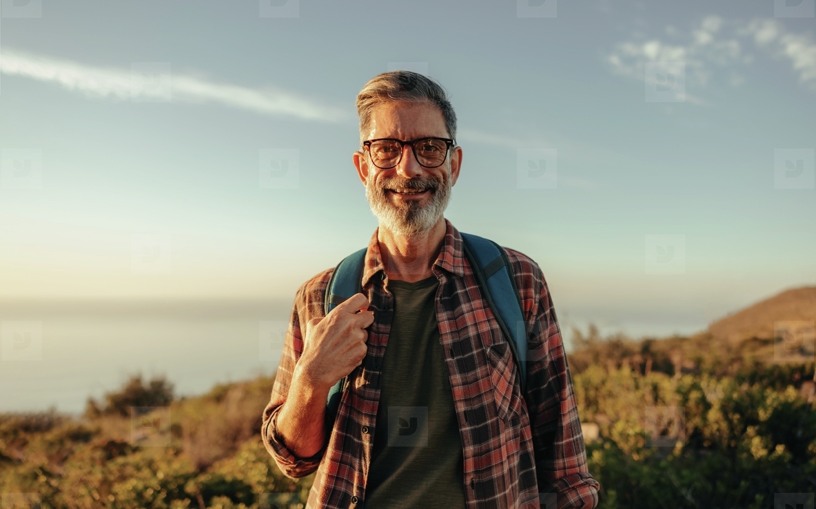 Mature hiker smiling at the camera while standing outdoors