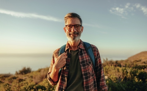 Mature hiker smiling at the camera while standing outdoors