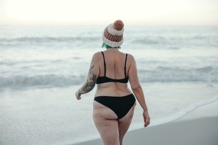 Winter bather walking towards the water at the beach