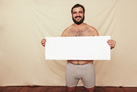 Body positivity activist holding a placard in a studio