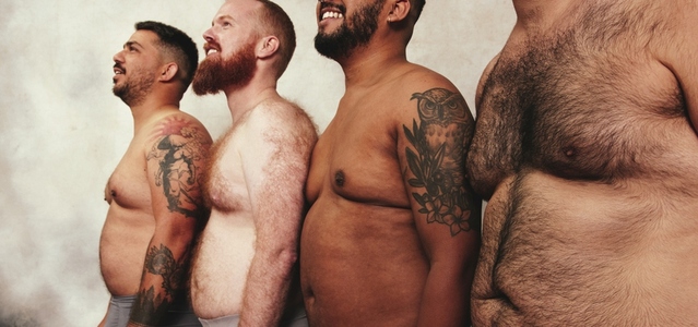 Carefree men with pot bellies standing together in a studio