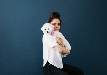 Portrait of a young woman with her white fluffy dog