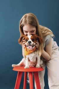 Close up portrait of a young woman and her little dog in studio