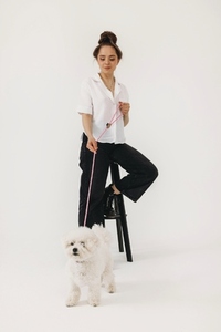 Woman sitting on a chair in studio with a dog on a lead