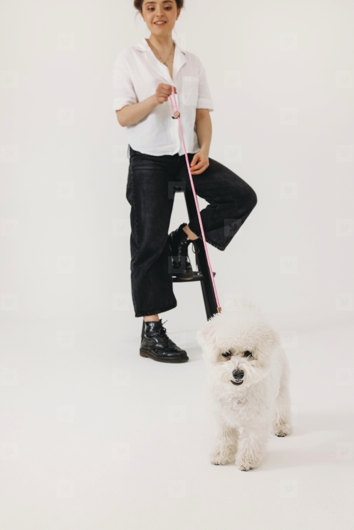 Young female with her fluffy dog against white background