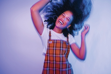 Energetic young woman dancing and whipping her hair