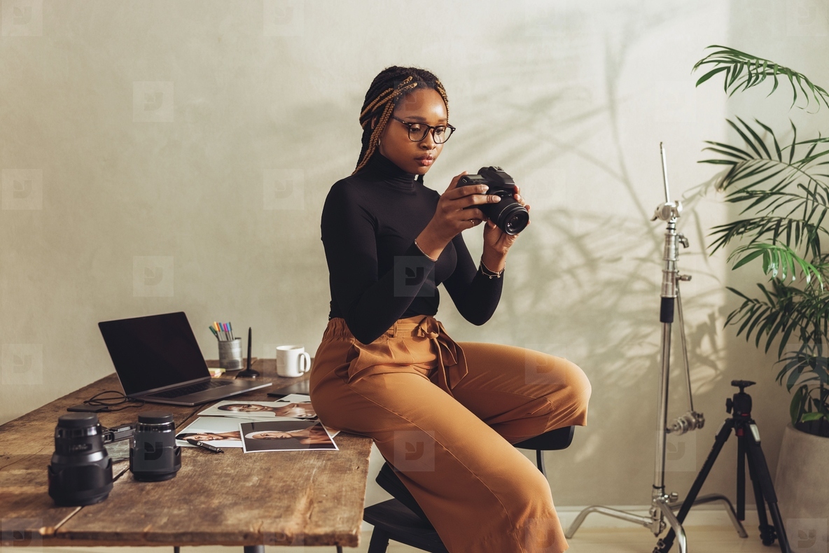 Creative photographer holding a dslr camera in her office