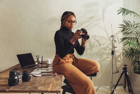 Creative photographer holding a dslr camera in her office