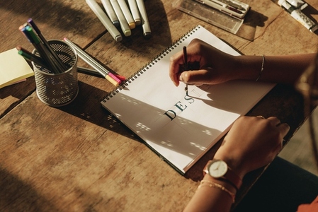 Woman drawing on a note pad at her desk