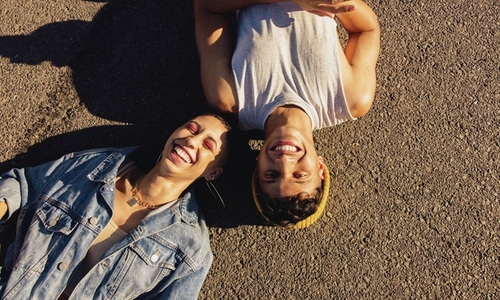 High angle view of two friends lying  down outdoors