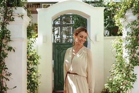 Smiling young woman standing outside a luxury holiday home