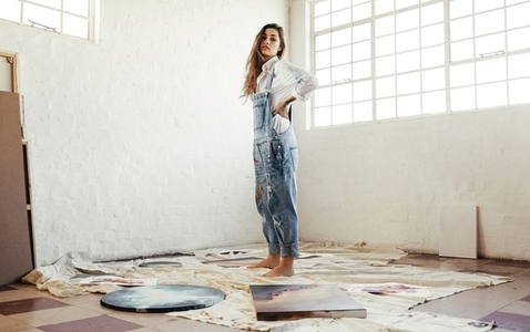 Artist standing in the middle of her paintings