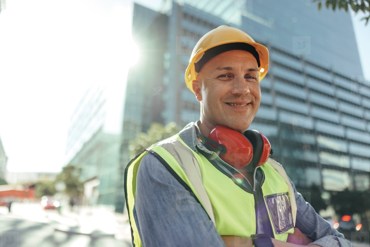Happy construction worker smiling at the camera in the city