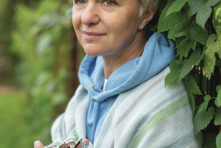 Woman wrapped in blanket at ivy bush