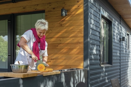 Woman slicing butternut squash on patio
