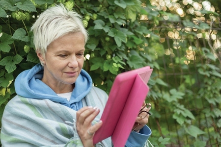 Woman using digital tablet in garden