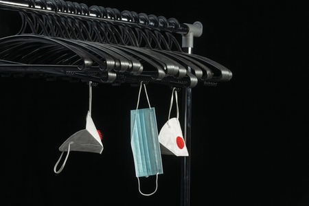 Protective COVID 19 face masks hanging from hangers