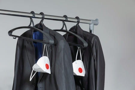 Business suit jackets and protective face masks hanging