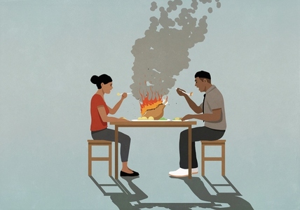 Couple eating burning turkey dinner at table