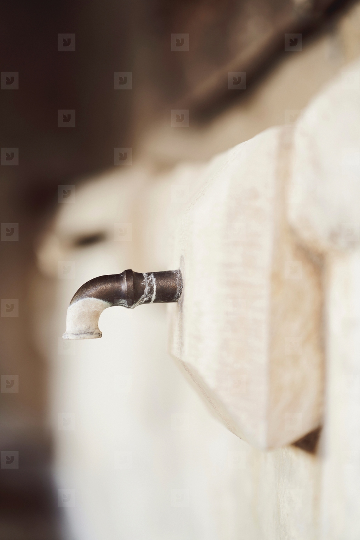 Paint on faucet at stone wall