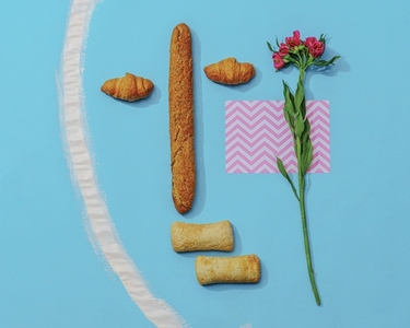Arrangement of various breads next to flower