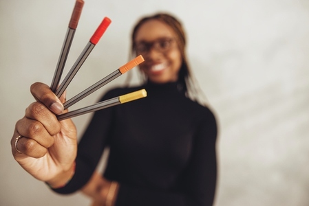 Creative designer holding coloured pens