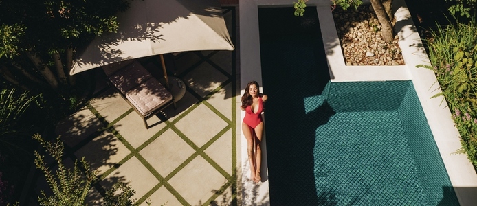 High angle view of a woman sunbathing next to a pool