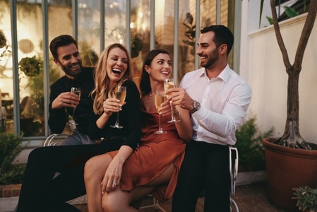 Smiling group of friends toasting champagne glasses