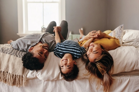 Happy family having fun together in their bedroom