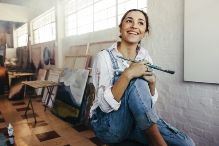 Excited female painter smiling in her art studio