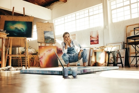 Happy young painter working in her art studio