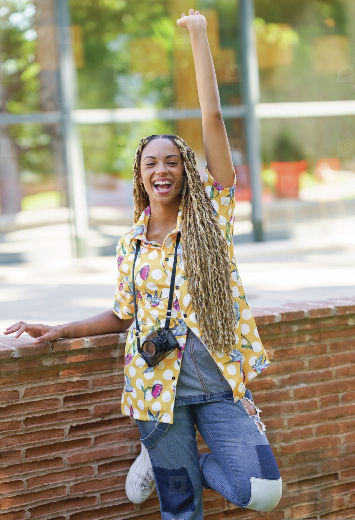 Black female with African braids  raising her arm in joy  Girl holding a camera