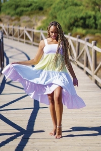 African woman wearing a beautiful dress on a boardwalk on the beach