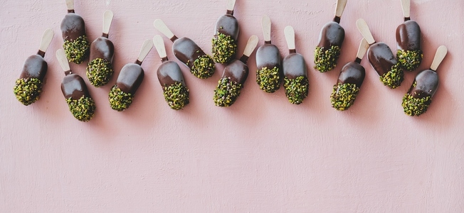 Chocolate glazed ice cream pops with pistachio icing  wide composition