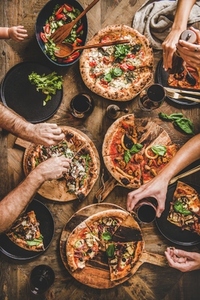 Family having pizza dinner party with red wine  top view