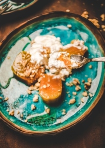Turkish pumpkin dessert with walnuts and cream in fork
