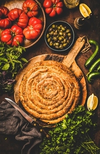 Flat lay of Turkish borek pie with spinach filling and vegetables