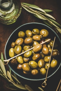 Flat lay of fresh harvested pickled green Mediterranean olives in bowl