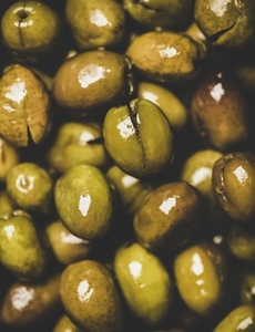 Flat lay of fresh harvested shiny seasonal pickled green Mediterranean olives