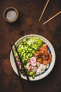 Hawaiian salmon poke bowl with vegetables  greens  rice  soy sauce