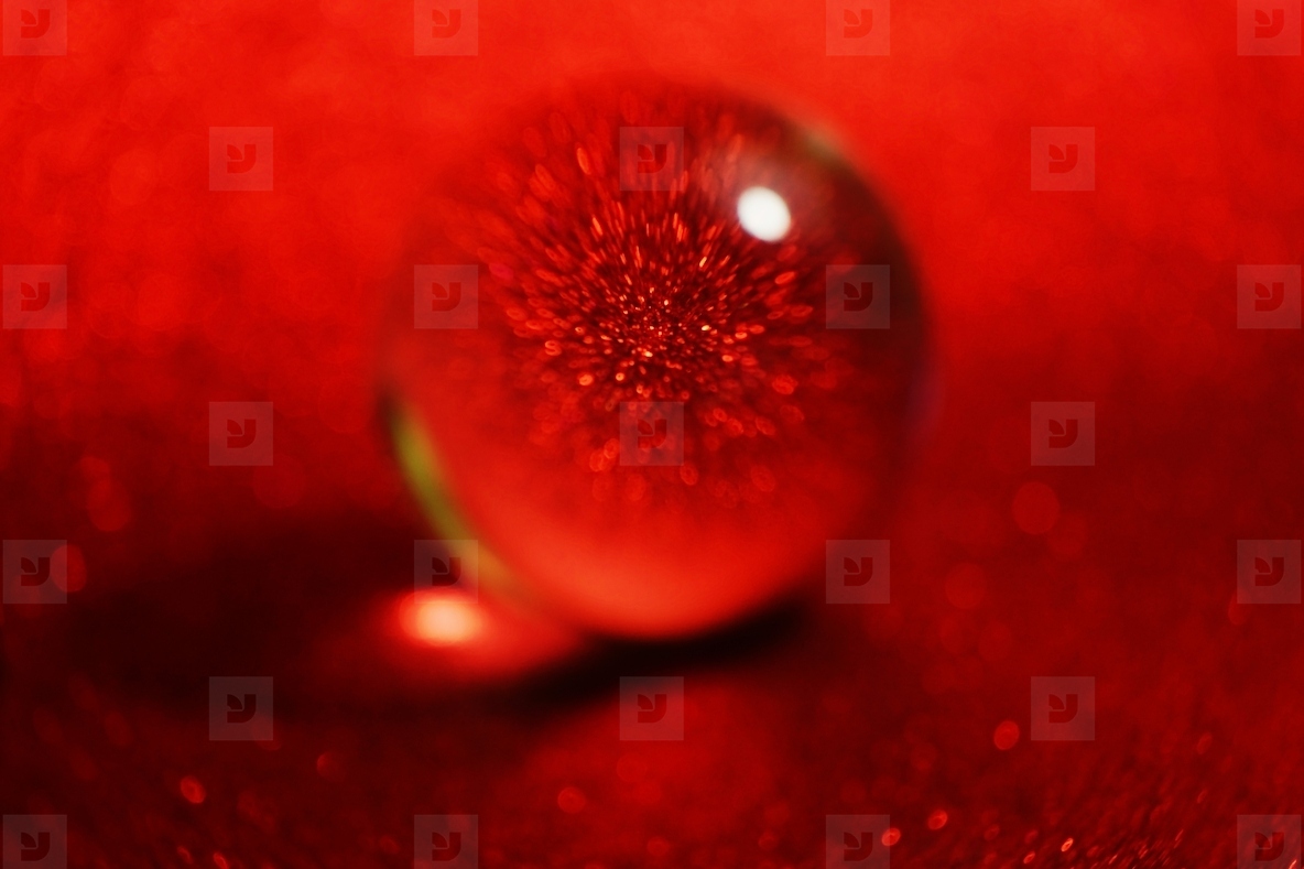 An amazing and beautiful macro of a crystal sphere on a red glit