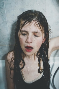 Artistic portrait of a young woman under shower water