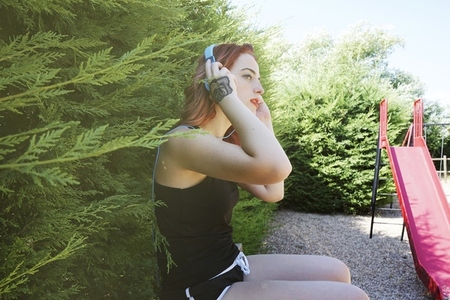 Young sporty woman listening to music