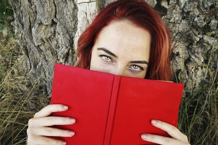 Young woman reading a red book