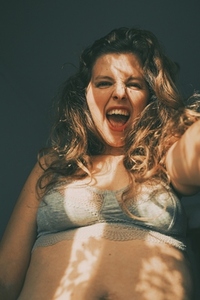 Body positive portrait of a young woman with light and shadows