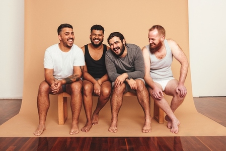 Four men laughing together in a studio