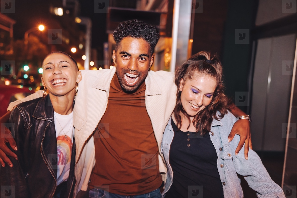 Three friends having fun in the city at night