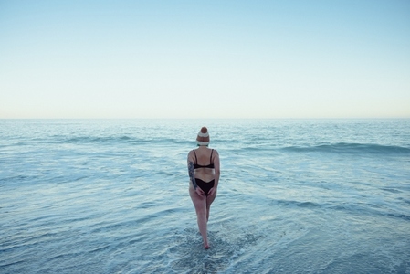 Anonymous woman going into the sea water in winter